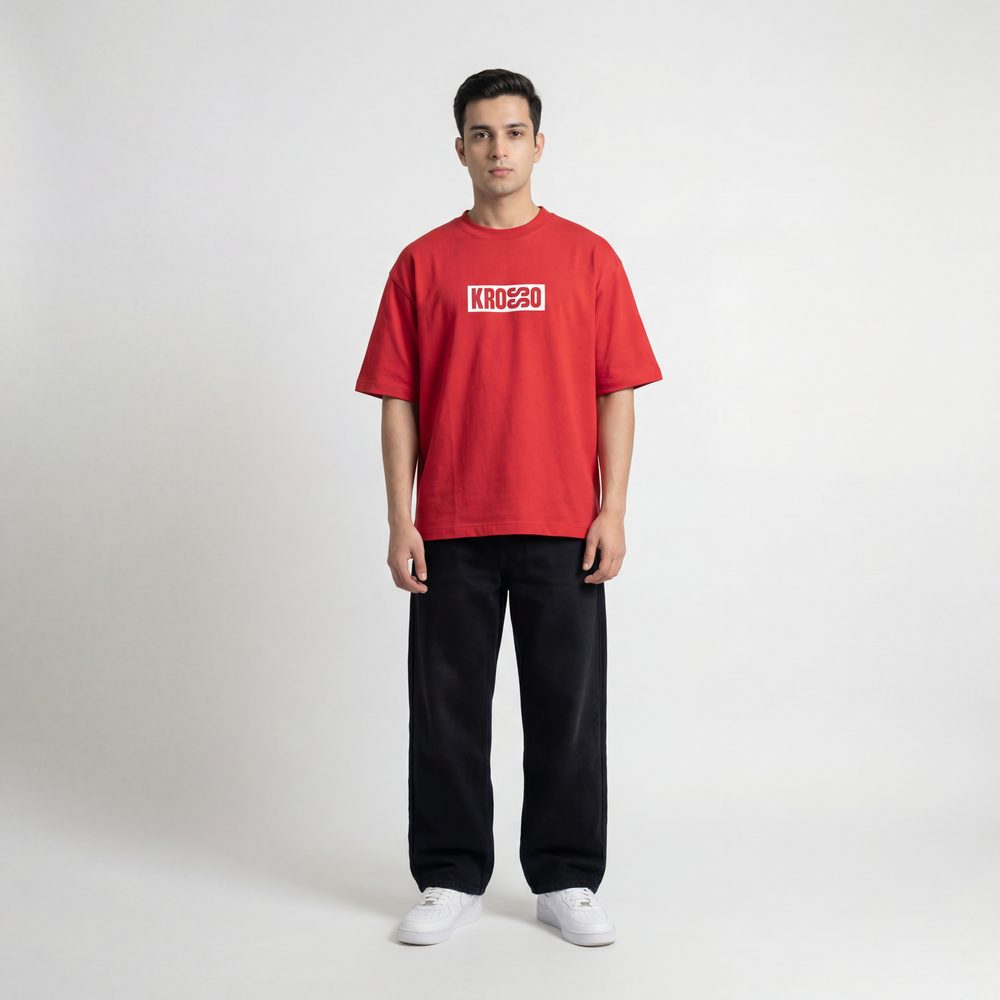 Full body front view of model wearing Krosso oversized red t-shirt with minimal logo print and oversized streetwear fit.