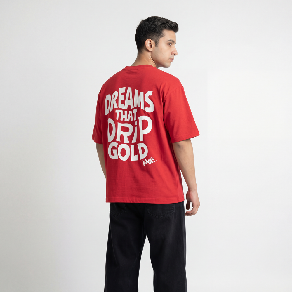Back view of model wearing Krosso “Dreams That Drip Gold” oversized red t-shirt with statement typography design.