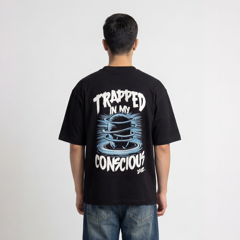 Back view of model wearing Krosso “Trapped In My Conscious” oversized black t-shirt with graphic illustration and typography print.