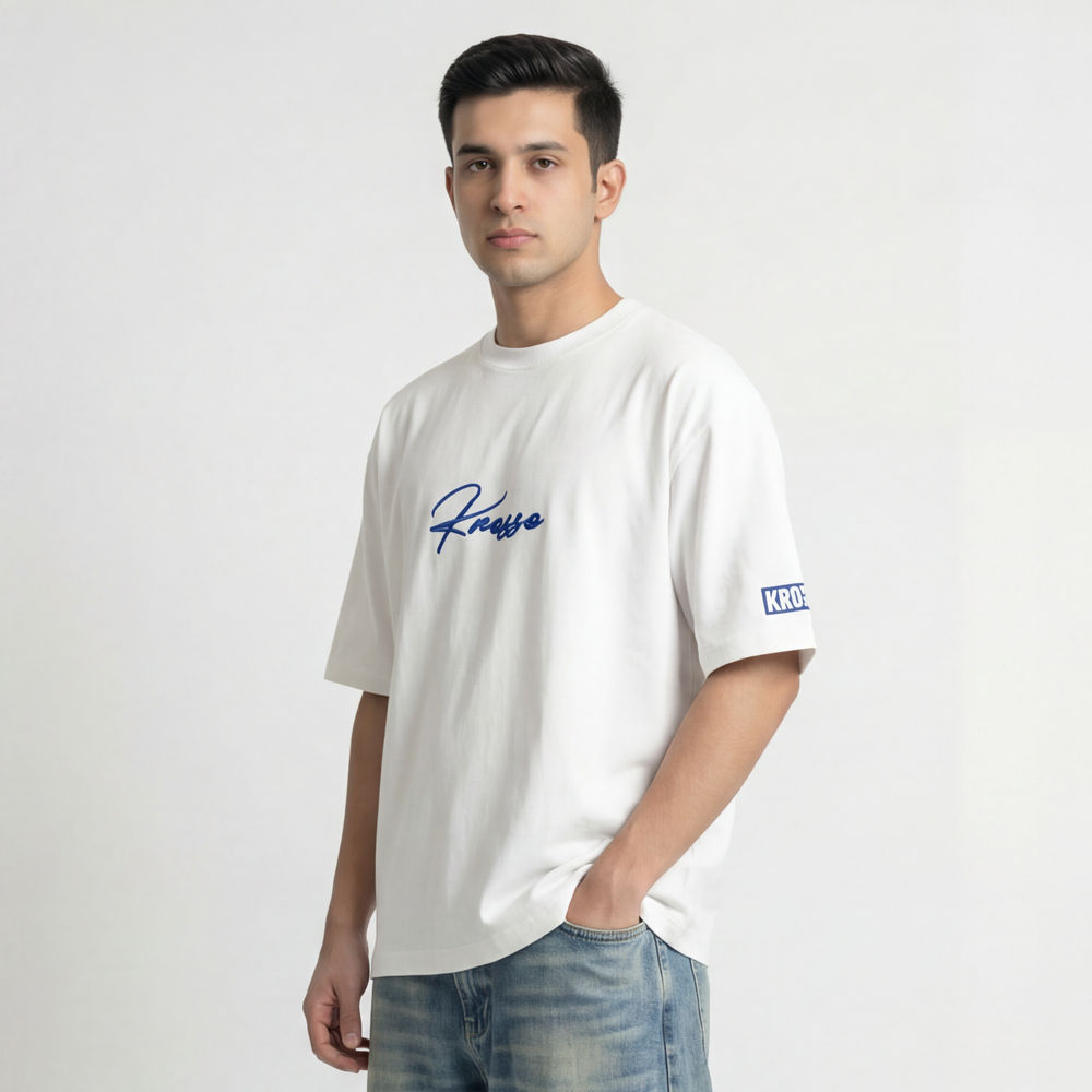 Side view of model wearing Krosso oversized white t-shirt with embroidered logo and oversized streetwear silhouette.